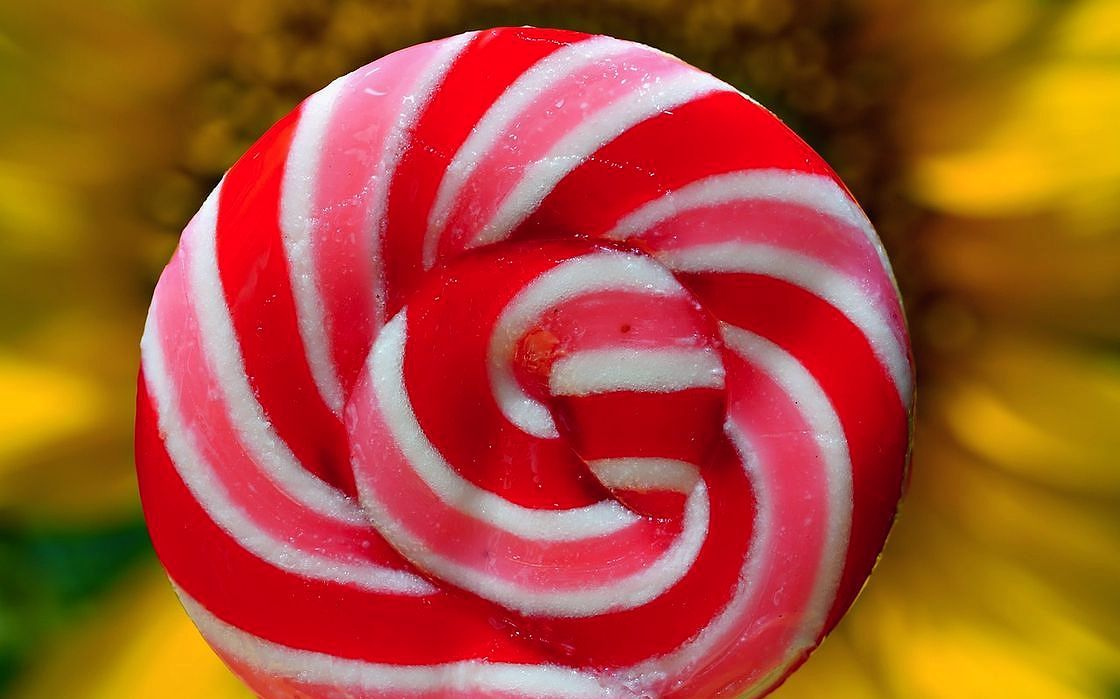 A handcrafted lollipop in jewel tones, held upright